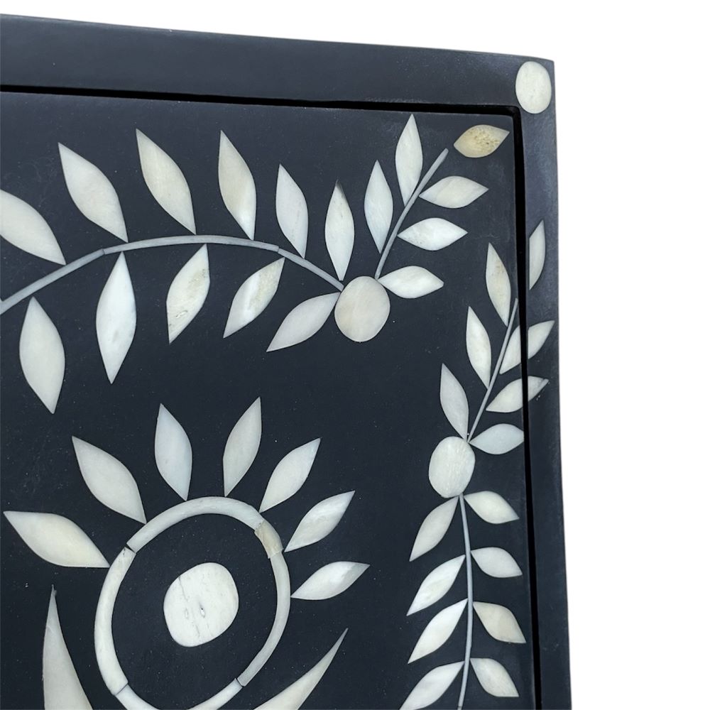 Close-up of floral bone inlay on a black cabinet